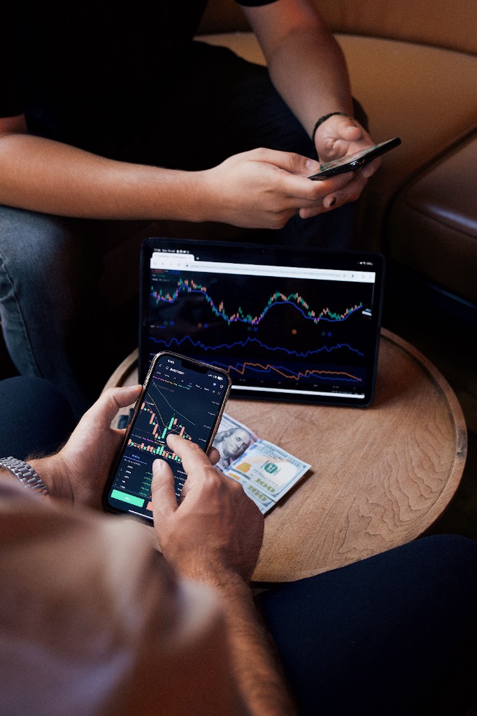 Finance professional reviewing markets on phone and tablet