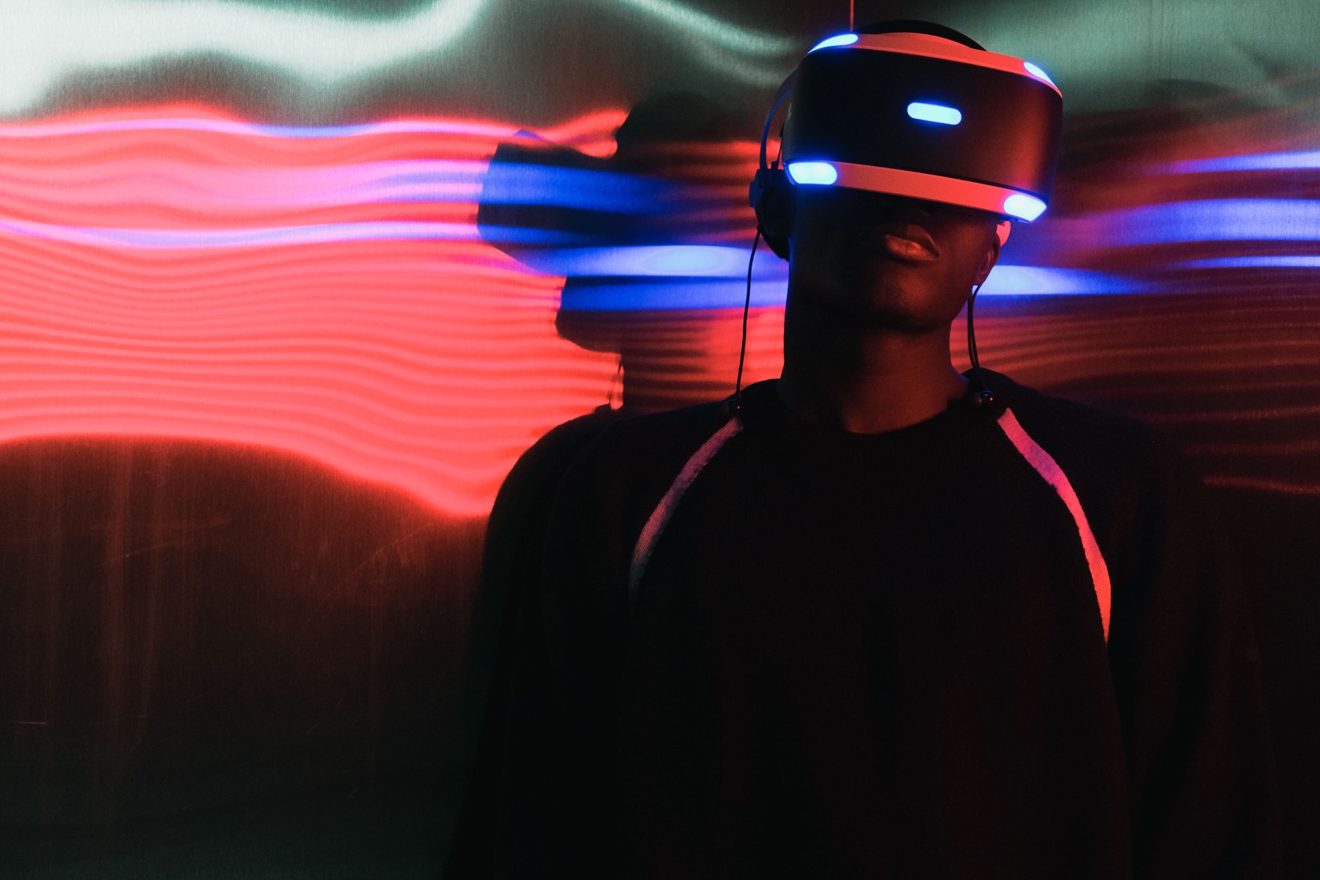 Person wearing a VR headset with neon lighting — technology and immersive media